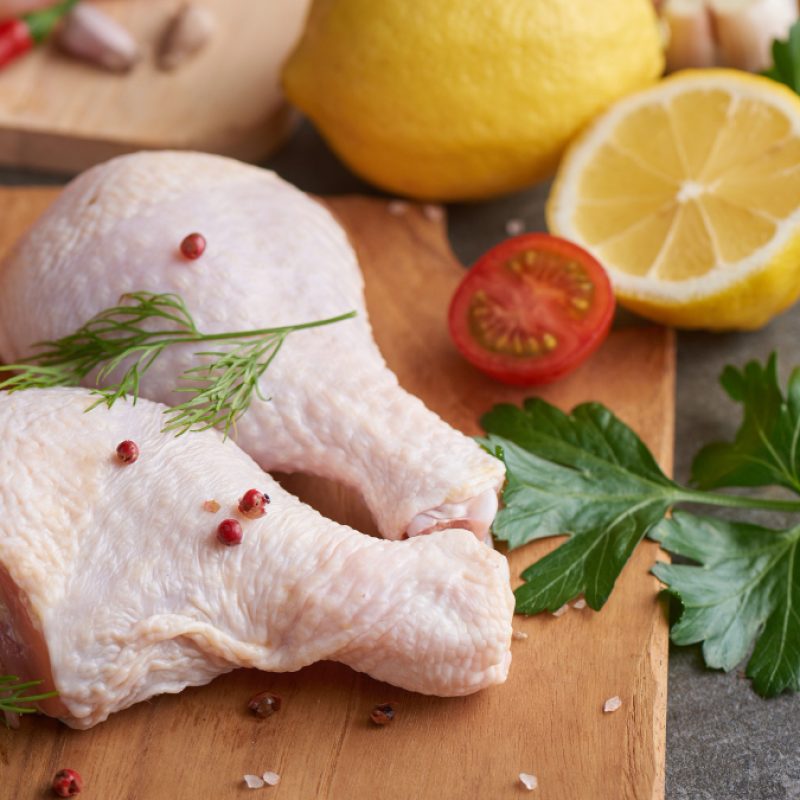 fresh-chicken-meat-portions-for-cooking-and-barbecuing-with-fresh-seasoning-raw-uncooked-chicken-leg-on-cutting-board